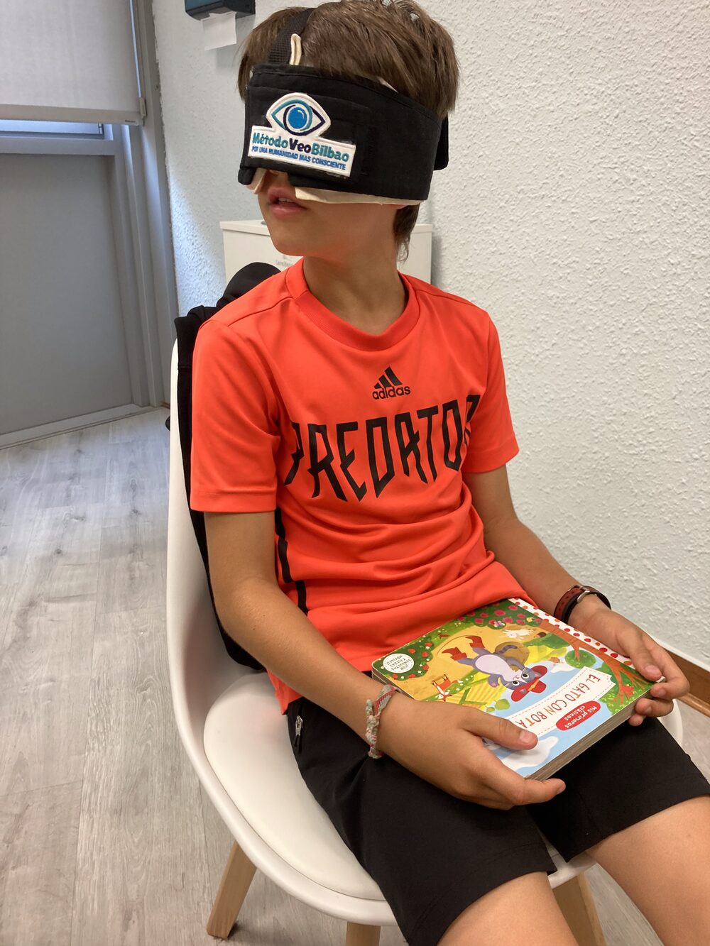 Niño leyendo un libro con el antifaz del Método VEO Bilbao